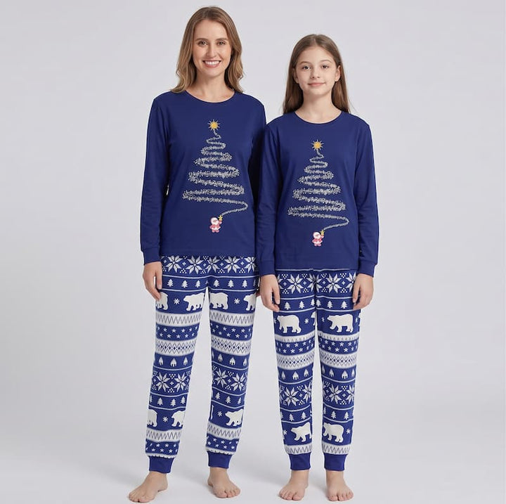 A woman and a girl modeling matching navy blue Christmas-themed long-sleeve pajamas with white patterns, including a tree made of song lyrics, a snowman, and polar bears on a light gray background.